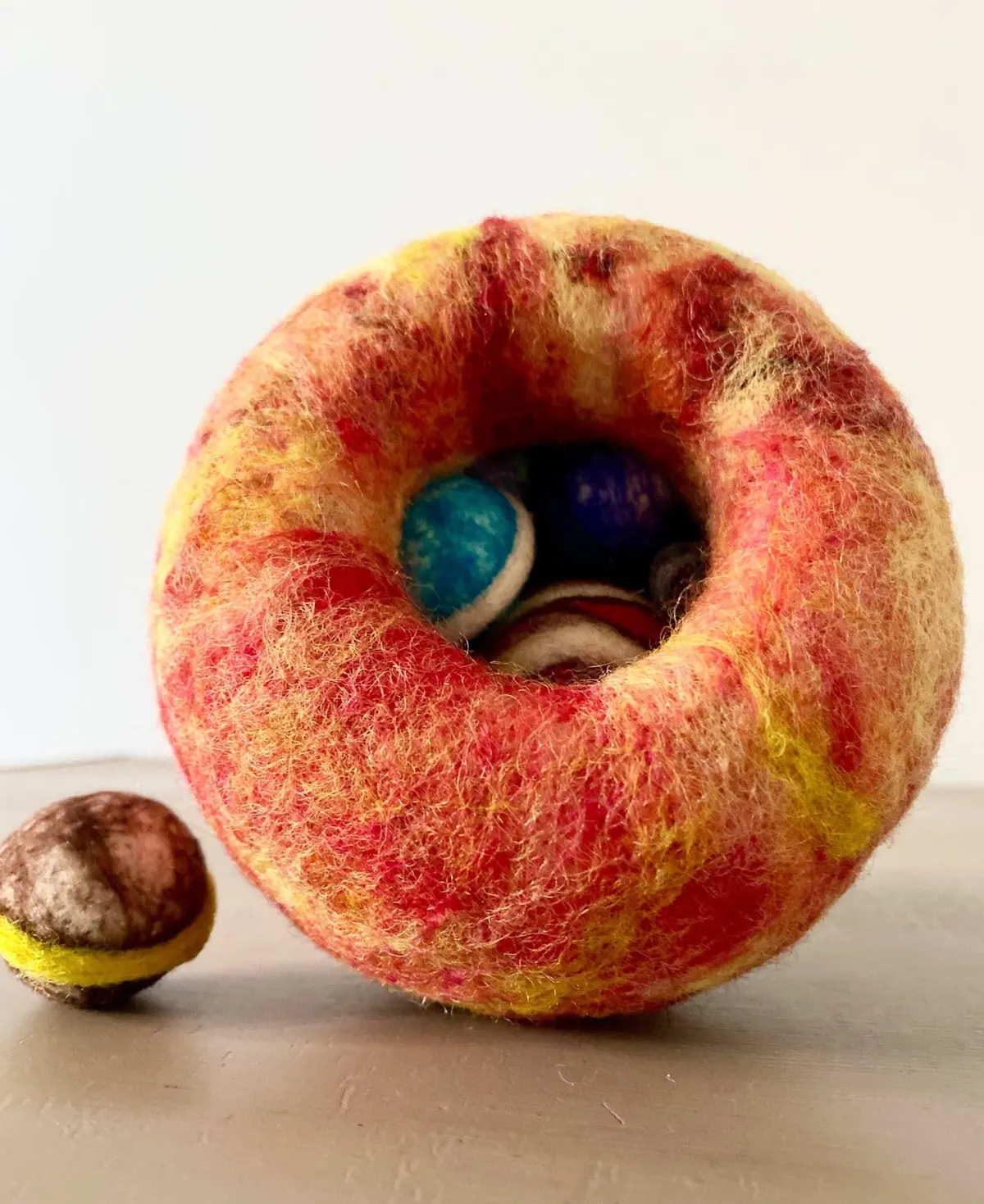 The hollow felted Sun opened at the front, planets visible nested inside.